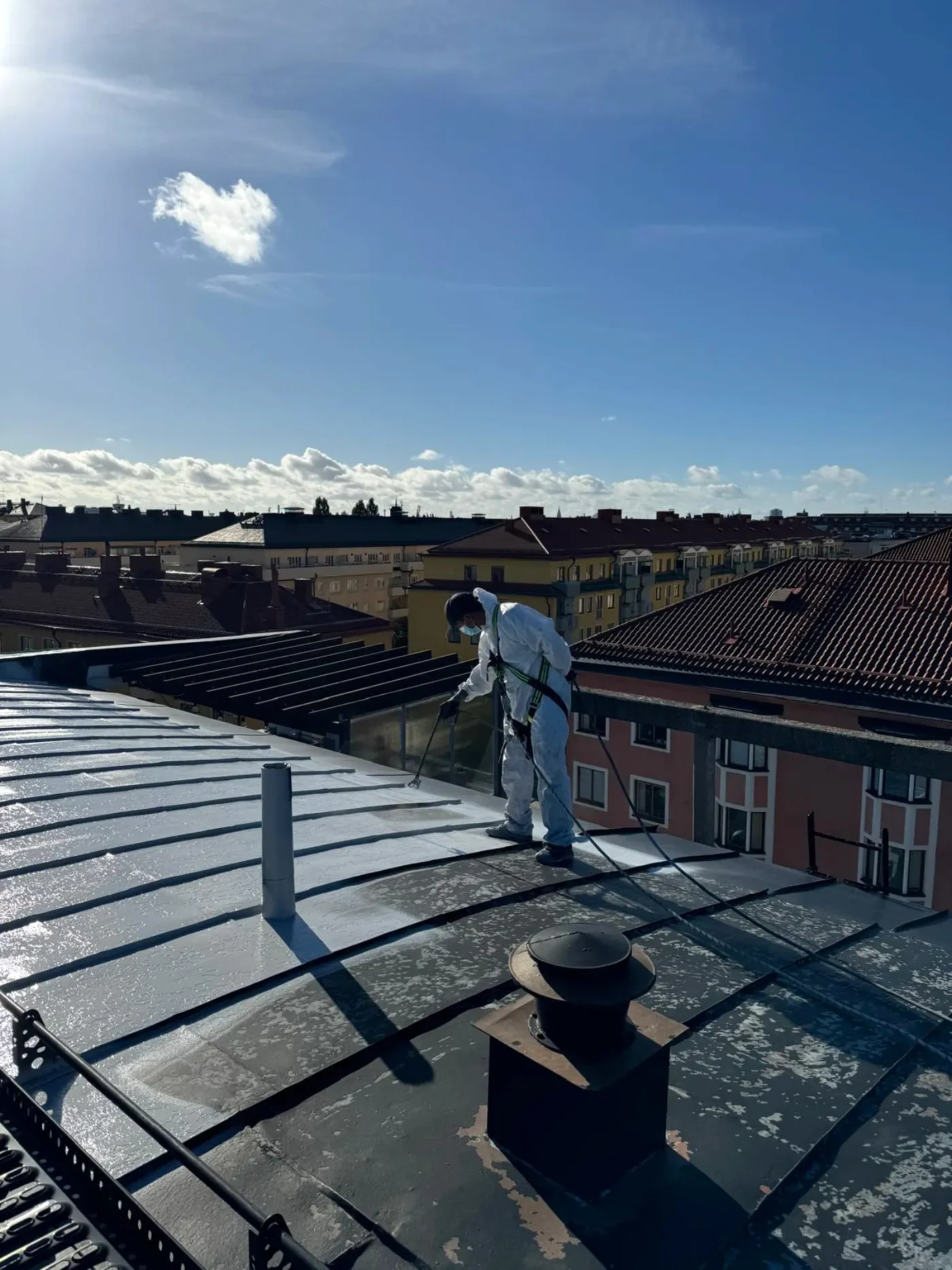 Takbehandling och målning på höghöjd med stadsvy