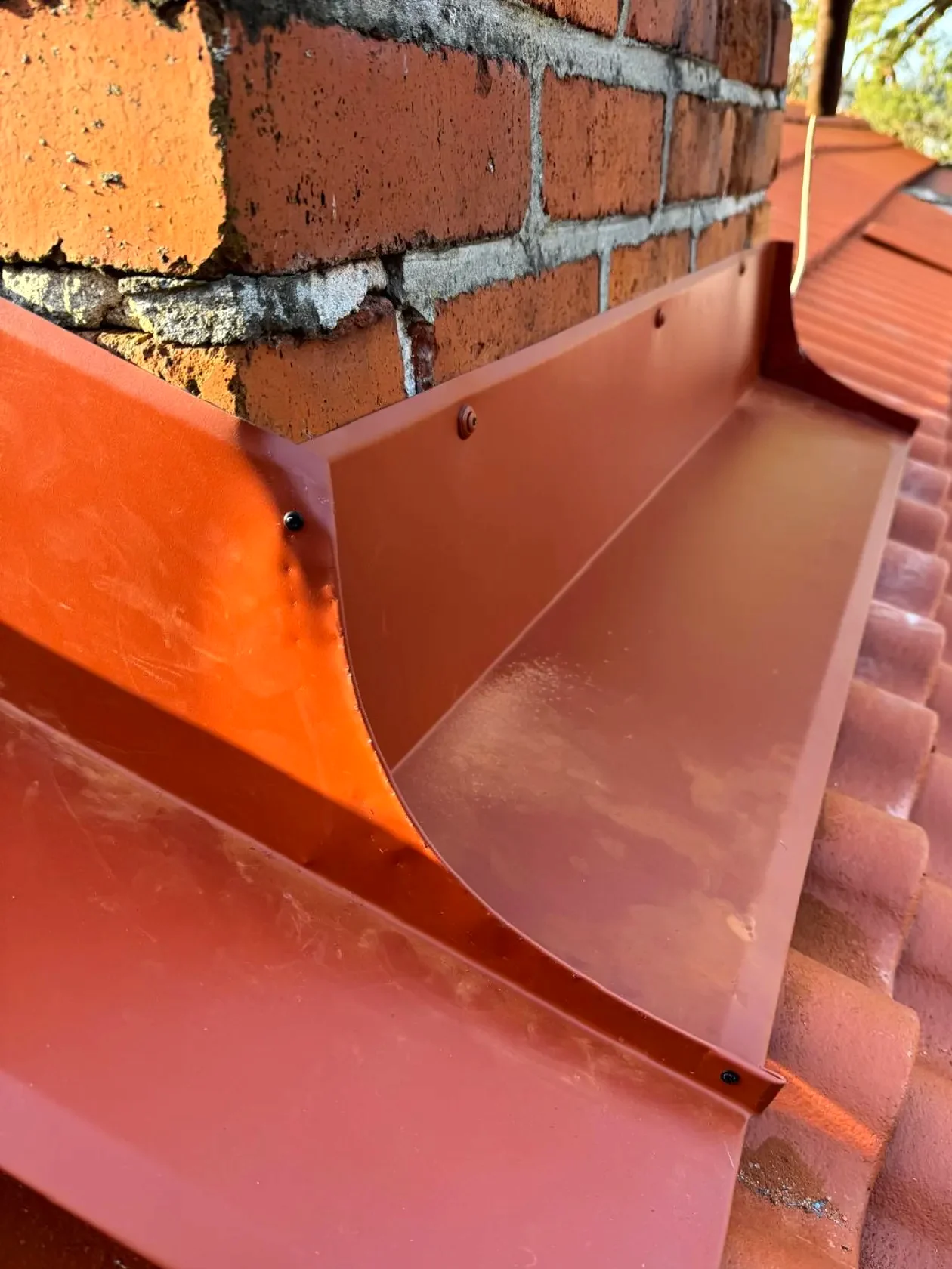 Detalj av plåtarbete mot skorstenstegel